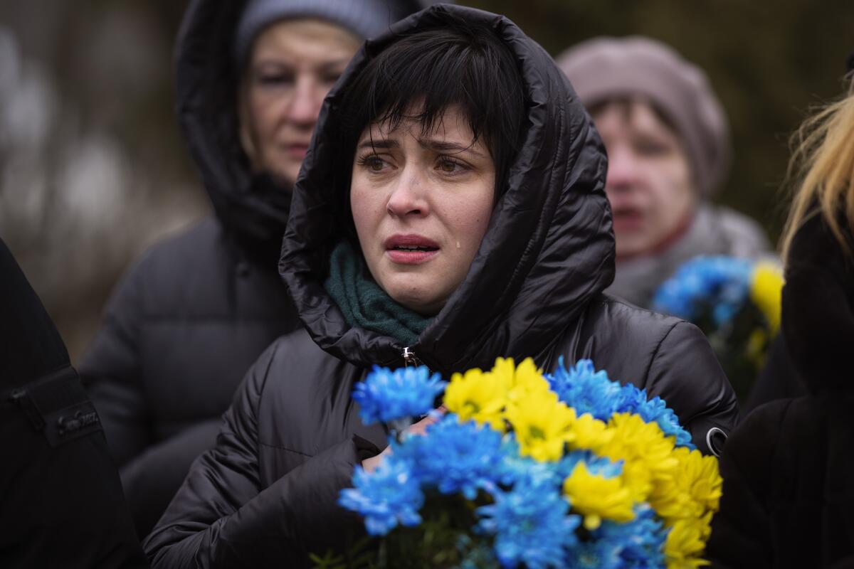 Una mujer llora durante un oficio fúnebre en el primer aniversario del inicio de la invasión rusa a Ucrania
