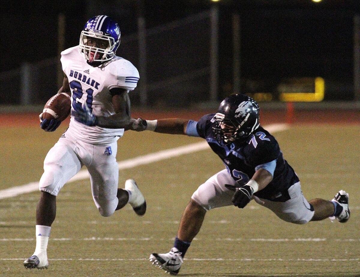 Burbank's James Williams (21) beats Crescenta Valley's Davo Hakobyan (72) to run for a touchdown in the first half in a Pacific League football game at Glendale High School on Friday, October 11, 2013.