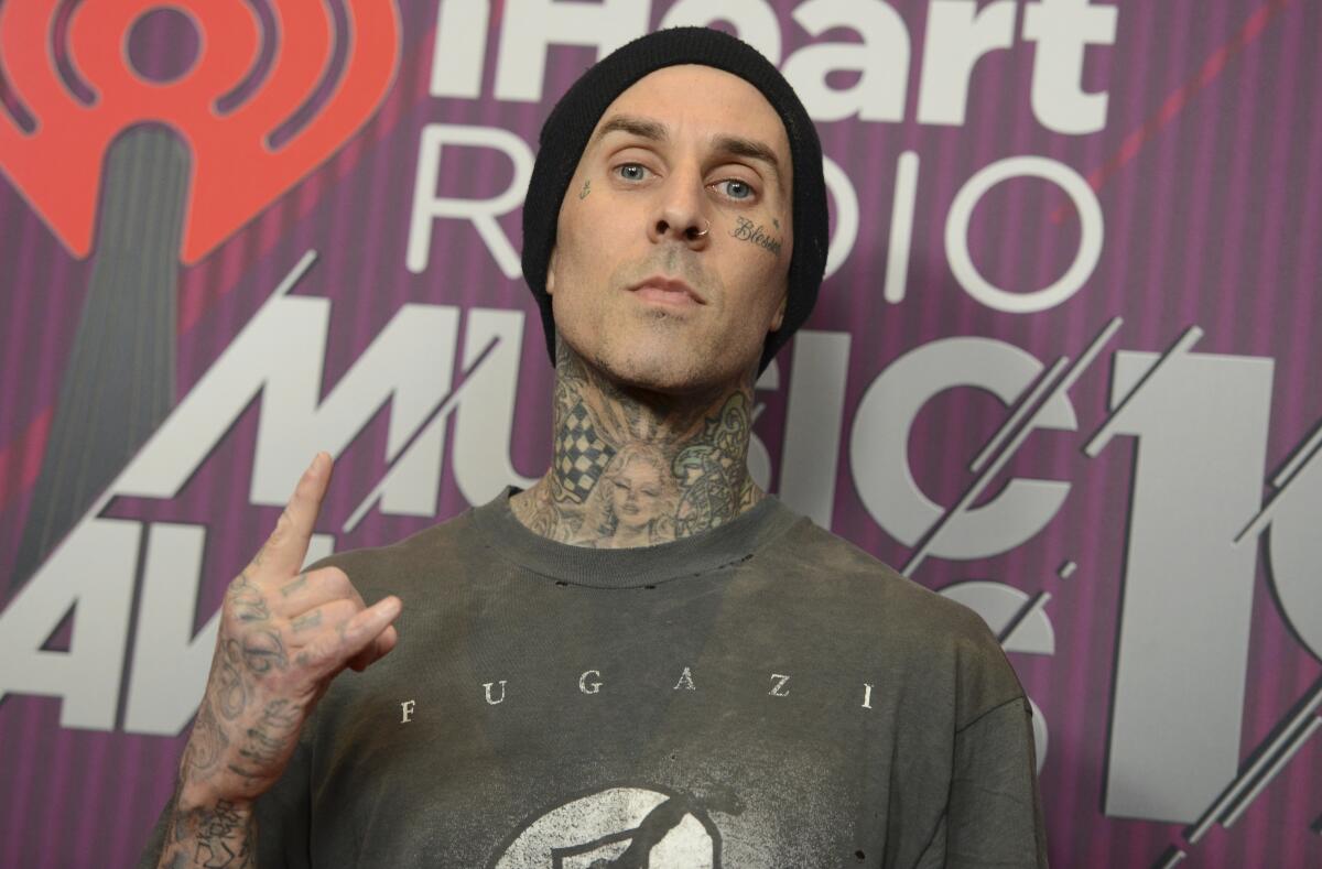 Travis Barker making the sign of the horns