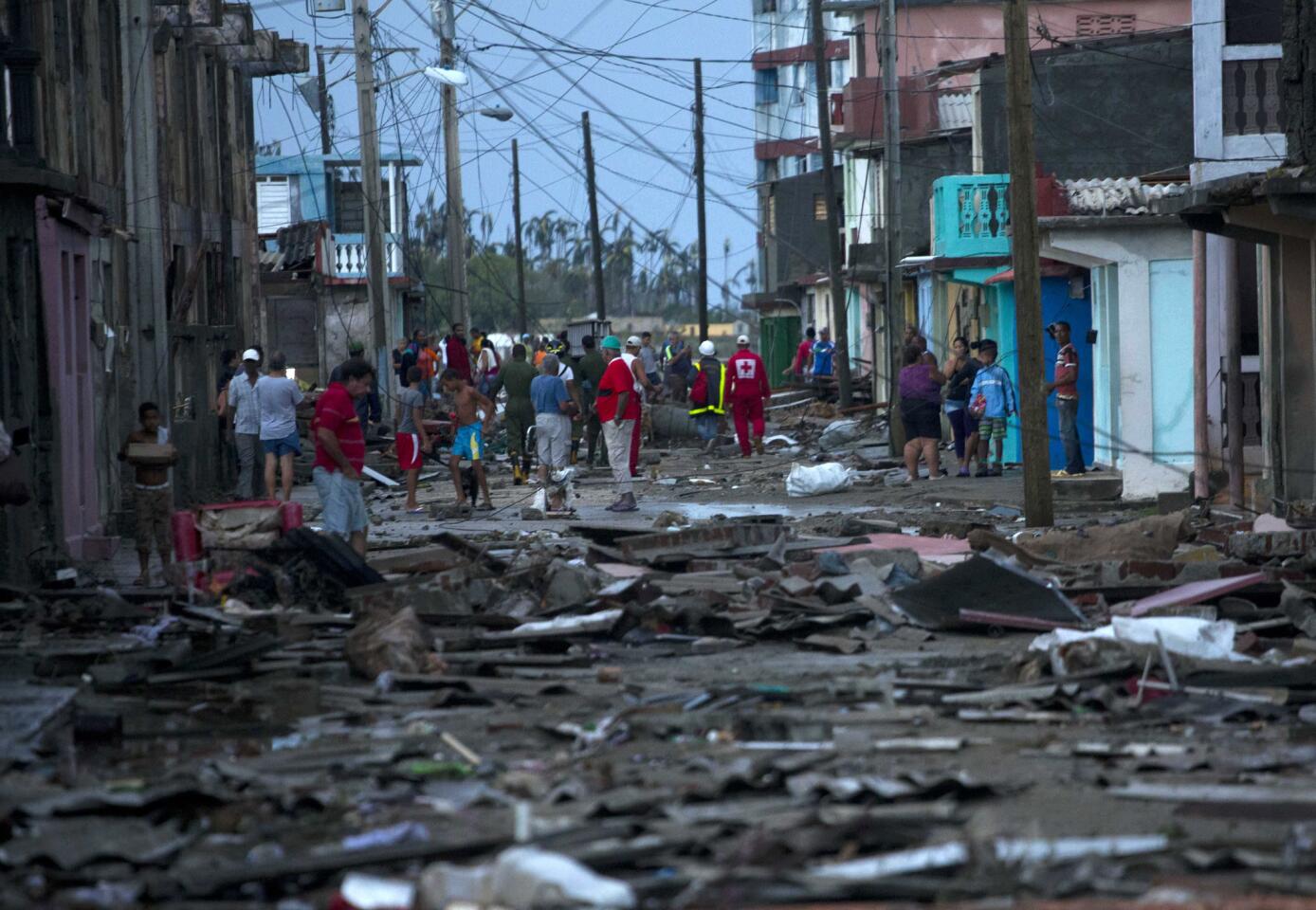 Red Cross workers and residents walk among the damage caused by Hurricane Matthew in Baracoa, Cuba, Wednesday, Oct. 5, 2016.