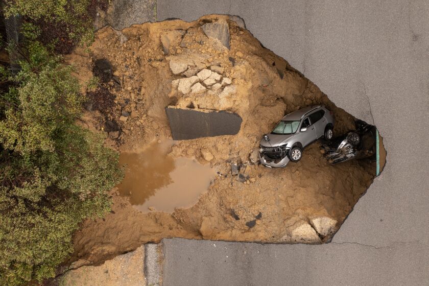 LOS ANGELES, CA - JANUARY 10: In an aerial view, a car and a pickup truck are seen inside a sinkhole as another storm created by a series of atmospheric rivers inundates California on January 10, 2023 in Los Angeles, California. Two vehicles containing four people fell into the sinkhole which had opened up under the road they were driving on during heavy rainfall in the the suburban Los Angeles neighborhood of Chatsworth. Two people were able to climb out before the hole grew larger, further consuming the vehicles. People from the other vehicle were rescued by about 50 firefighters using a high-angle rope and an aerial ladder to lower a firefighter into the hole and raise a young girl and a woman to the surface. Victims were taken to a hospital with minor injuries. Powerful storms have pounded much of the West Coast since the beginning of the new year, a striking contrast to the past three years of severe to extreme drought experienced by most of the state. The snowpack in the Sierra Nevada Mountains, which supplies water for millions of Californians, is now above average to date. Last winter, a fraction of average snowfall in the Sierras left the high mountain range virtually devoid of the usual summer snow patches. Though damaging yet not enough to make up for years of drought, the heavy precipitation brings a level of relief from an anticipated fourth year of drought in 2023. (Photo by David McNew/Getty Images)