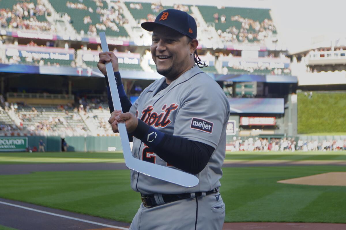 Miguel Cabrera holds a silver hockey stick presented by the Minnesota Twins