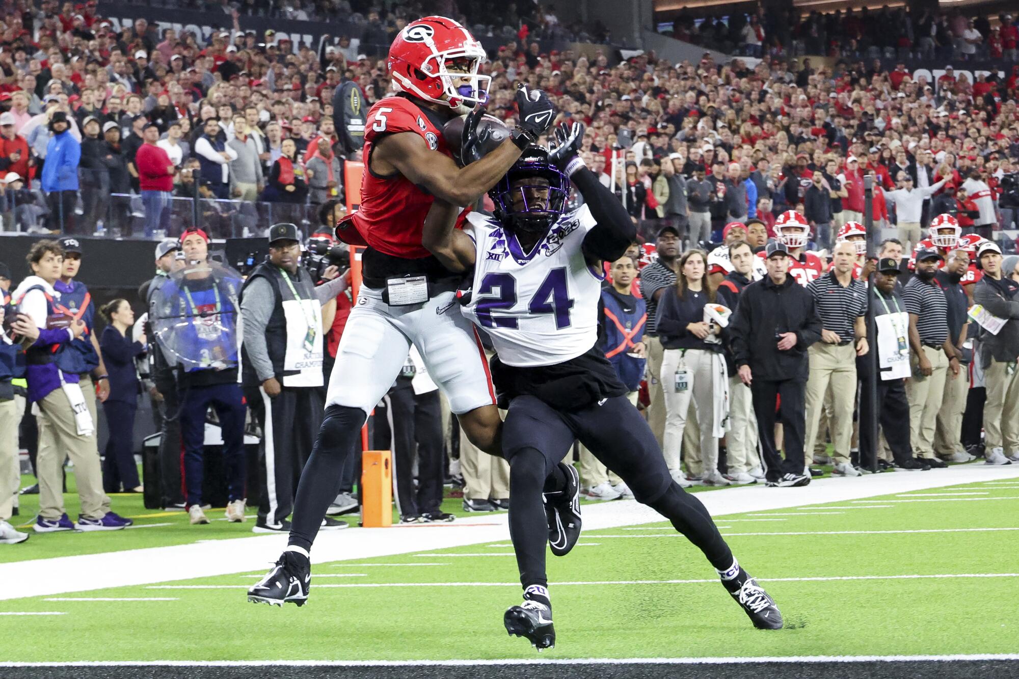 Georgia wide receiver Adonai Mitchell (5) catches a touchdown pass over TCU cornerback Josh Newton in the first half.