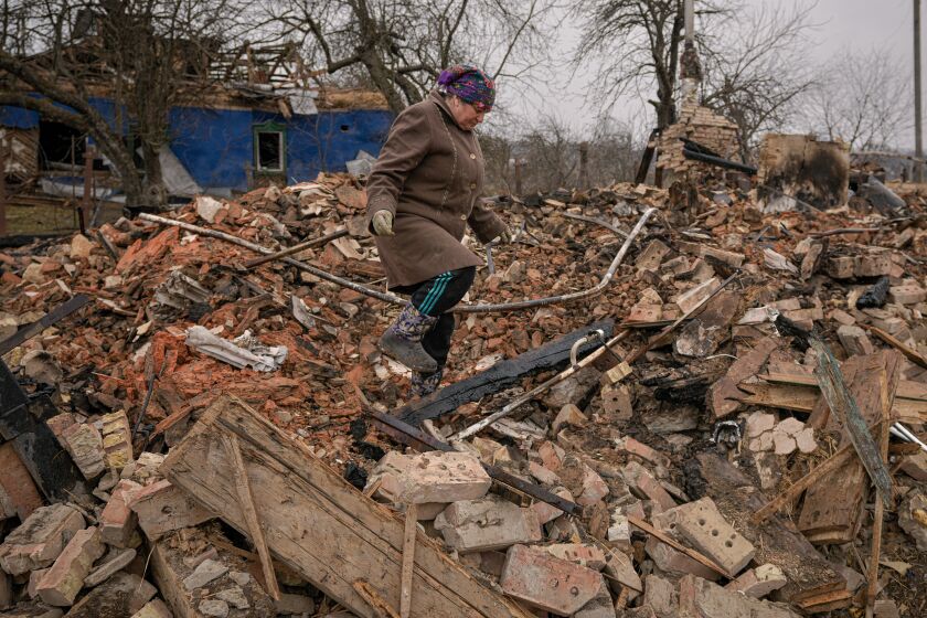 A local resident looks for personal items in the rubble of her house on the outskirts of Kyiv, March 30, 2022.