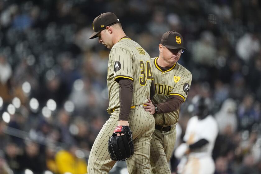 San Diego Padres starting pitcher Michael King, front, is pulled form the mound by San Diego Padres manager Mike Shildt in the fourth inning of a baseball game against the Colorado Rockies Tuesday, April 23, 2024, in Denver. (AP Photo/David Zalubowski)