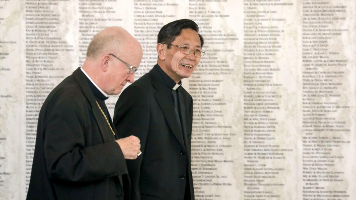 Bishop of Orange Kevin Vann, left, walks with new Bishop-elect Thanh Thai Nguyen at Christ Cathedral in Garden Grove.