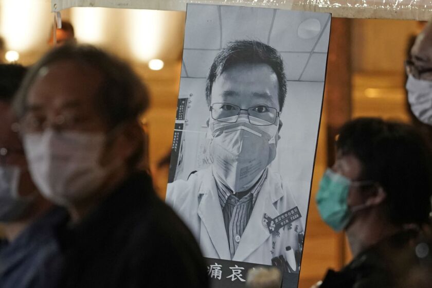 A photo of Dr. Li Wenliang is displayed during a vigil on Feb. 7. Wenliang was officially reprimanded for warning about the coronavirus outbreak and later died of the disease.