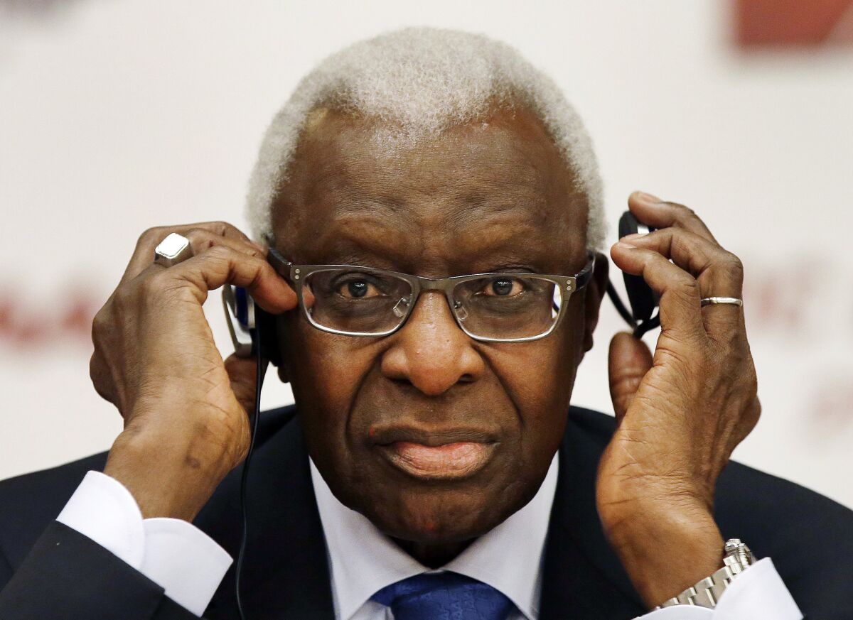 FILE - Lamine Diack adjusts his headphones during a joint IOC and IAAF news conference on the site of the World Athletic Championships in Beijing on Aug. 21, 2015. Lamine Diack, the controversial former president of the International Athletics Federation, has died, his family said Friday, Dec. 3, 2021. He was 88. (AP Photo/Kin Cheung, File)