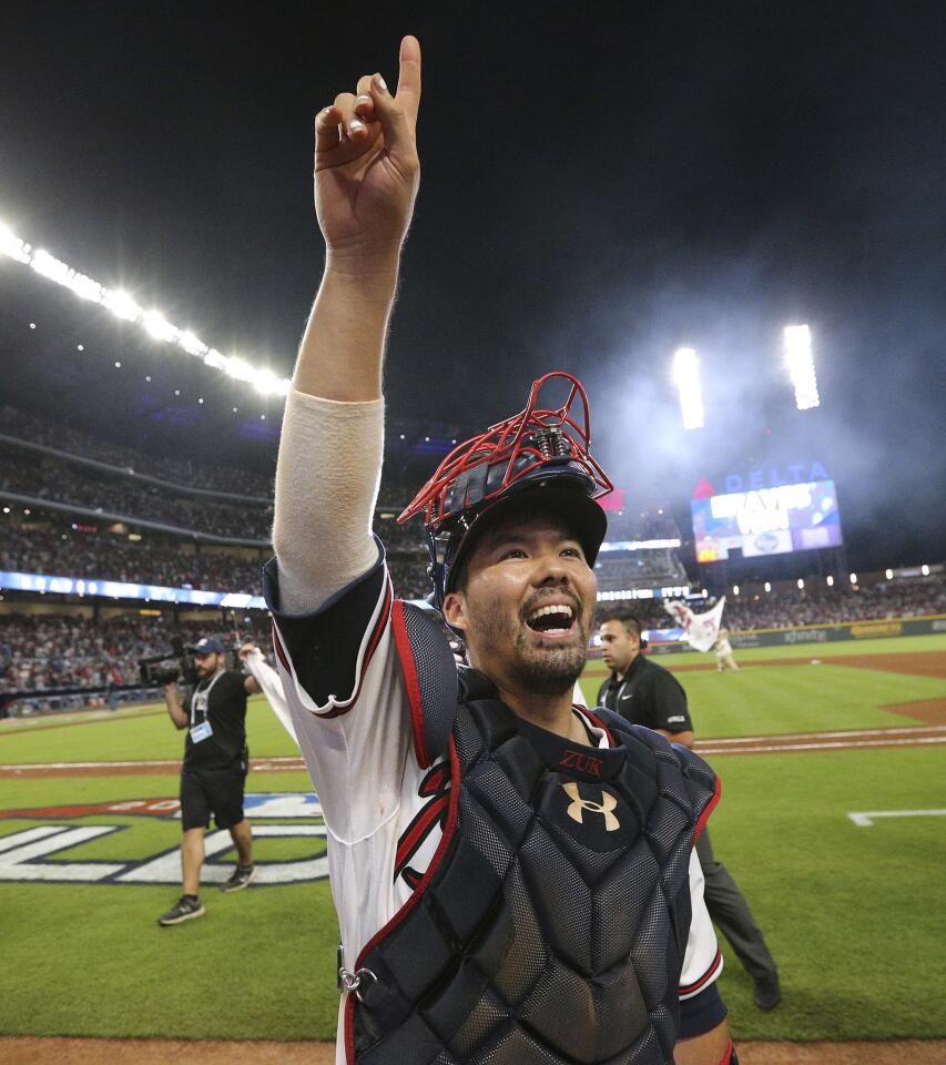 Atlanta Braves catcher Kurt Suzuki salutes the fans while celebrating beating the Los Angeles Dodgers in Game 3 of MLB baseball's National League Division Series in Atlanta on Sunday, Oct. 7, 2018. The Braves won 6-5.