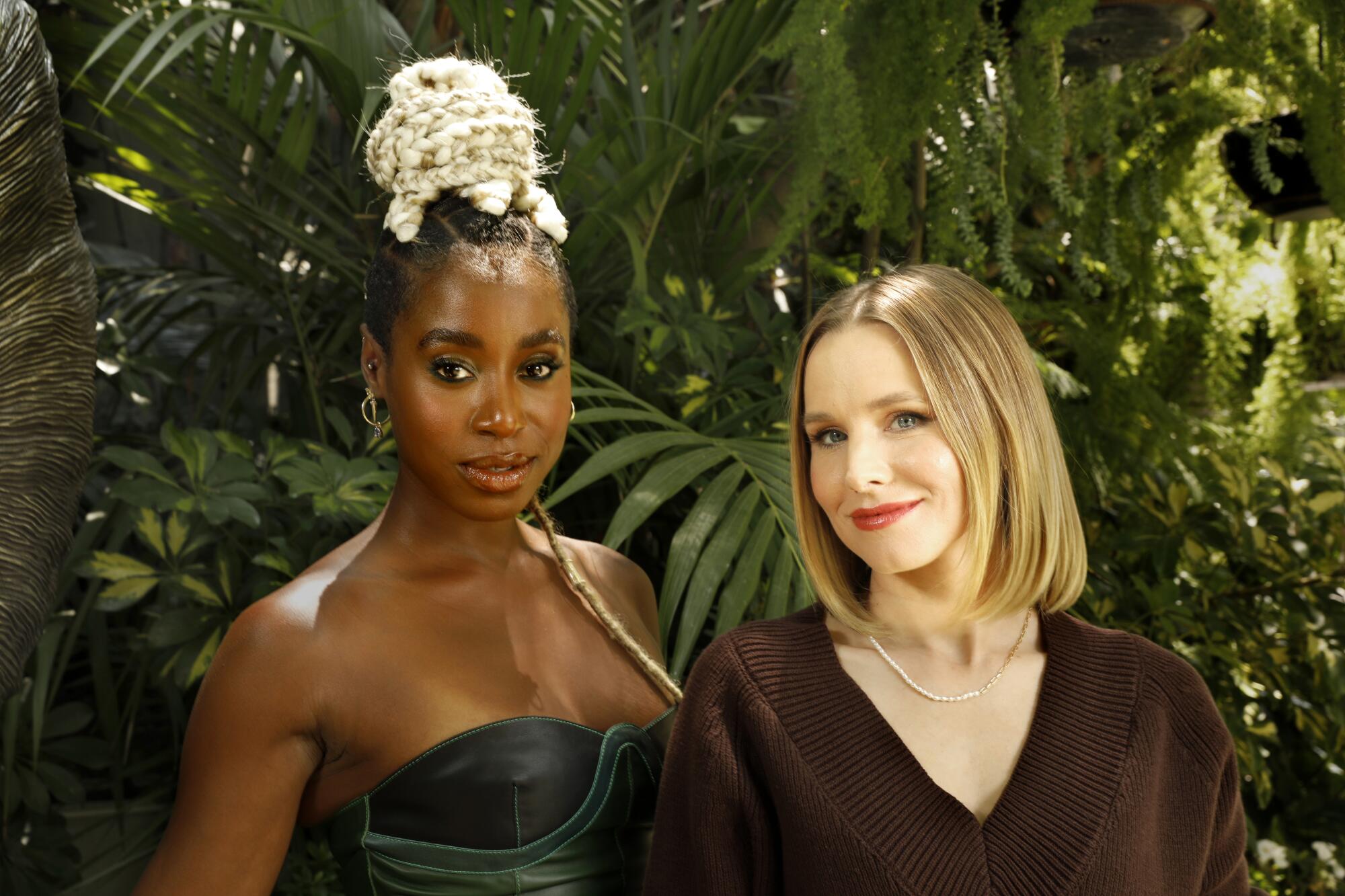 Actresses Kirby Howell-Baptiste and Kristen Bell against a background of tropical plants