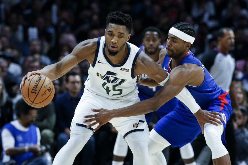 Utah Jazz's Donovan Mitchell (45) is defended by Los Angeles Clippers' Maurice Harkless (8) during the second half of an NBA basketball game Sunday, Nov. 3, 2019, in Los Angeles. The Clippers won 105-94. (AP Photo/Ringo H.W. Chiu)