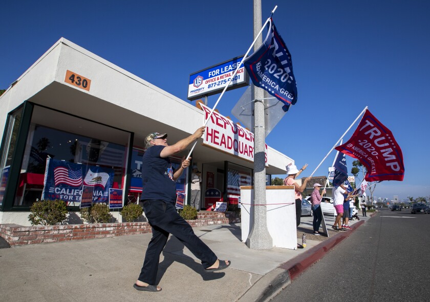  Trump supporters shout to  motorists in front of GOP headquarters in Newport Beach