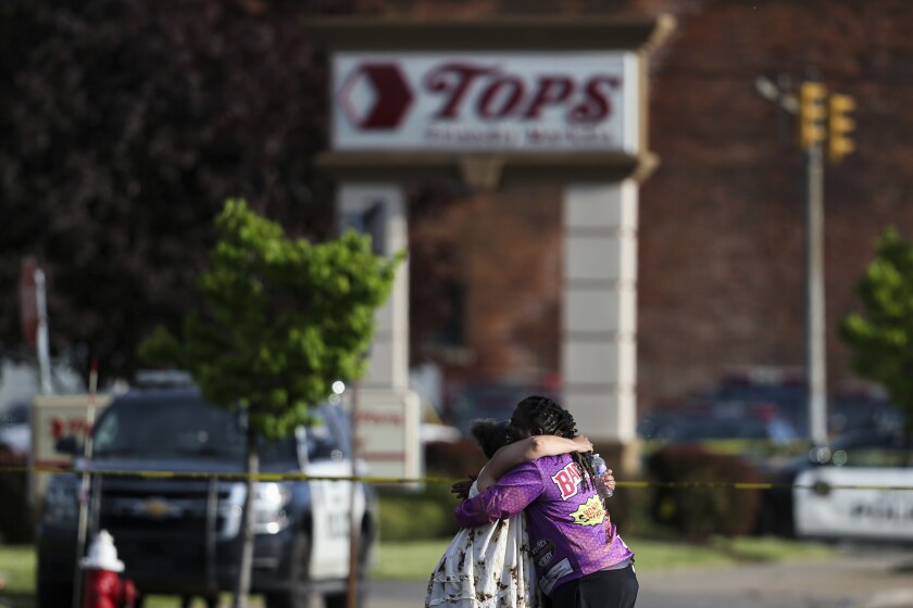 Un par de personas se abraza afuera del supermercado donde se registró un tiroteo el sábado 14 de mayo de 2022, en Buffalo