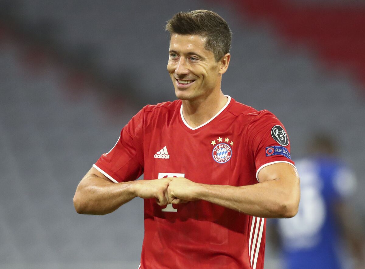 Bayern's Robert Lewandowski celebrates after scoring his team's first goal from the penalty spot during the Champions League round of 16 second leg soccer match between Bayern Munich and Chelsea at Allianz Arena in Munich, Germany, Saturday, Aug. 8, 2020. (AP Photo/Matthias Schrader)