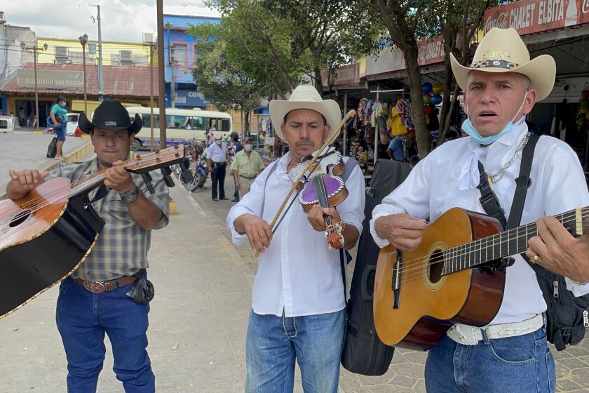 Roving musicians offer their services in the central park of Sensuntepeque, Cabanas, in search of Salvadorans visiting from the United States.