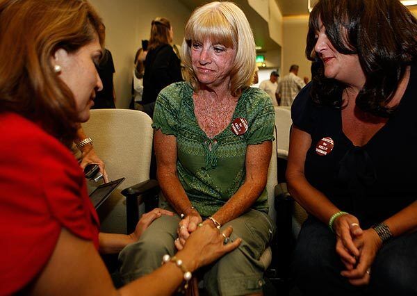 Fullerton City Council member Sharon Quirk-Silva, left, and Fullerton resident Erin Lewis, right, comfort Cathy Thomas after the council voted to retain an outside investigator to look into the death of Thomas' son, Kelly, after a confrontation with Fullerton police.