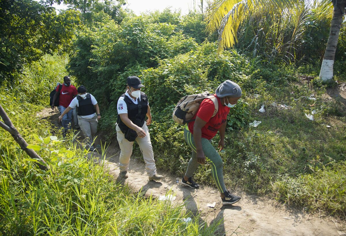 Instituto Nacional de Migración officials take a group of Haitian migrants into custody
