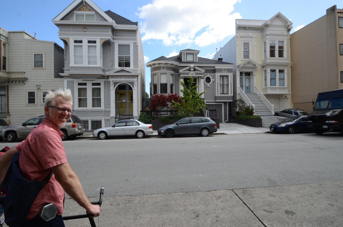 Guide Jefferson McCarley in front of three Victorian houses that survived the 1906 San Francisco quake.
