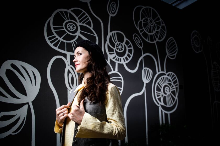 San Marcos, CA - January 04: Anna Pearson, a Ukrainian-born artist who moved to San Diego in 2017, poses for a portrait near a mural she painted outside the North City development on Wednesday, Jan. 4, 2023 in San Marcos, CA. The mural is meant resemble samsara, the Buddhist cycle of birth, death, and rebirth.(Meg McLaughlin / The San Diego Union-Tribune)