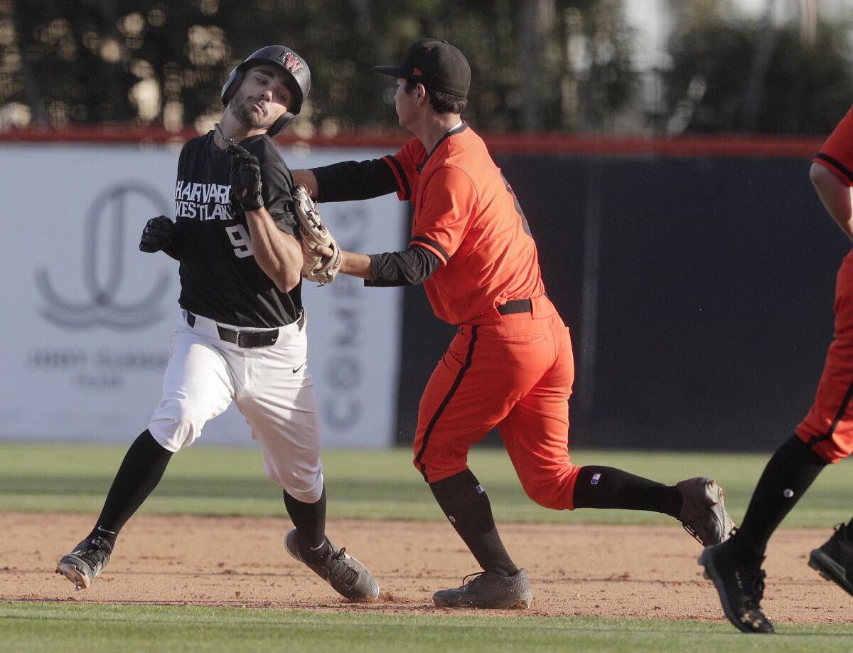 Harvard-Westlake's Tyler Ganus is caught in a pickle and is tagged out by Huntington Beach's Mark Muranaka in a nonleague game on Wednesday.