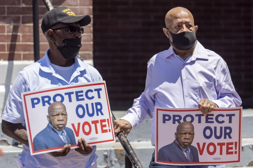 Henry Allen, left, and Charles Mauldin stand for the protection of voting rights at the John Lewis Advancement Act Day of Action, a voter education and engagement event taking place at Brown Chapel A.M.E. Church, Saturday, May 8, 2021, in Selma, Ala. Both men participated in the 1964 - 1965 Selma civil rights movement. (AP Photo/Vasha Hunt)