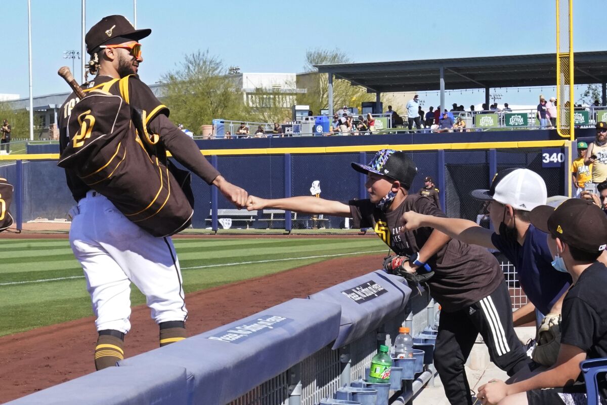 A young fan bumps fists with Fernando Tatis Jr. at a spring training game in 2021