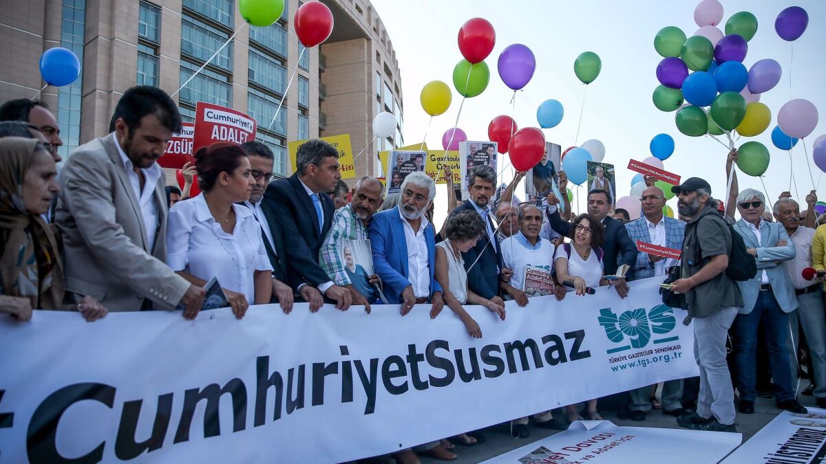 Several hundred people chant slogans as they gathered outside the central court in Istanbul, Turkey, to protest against the prosecution of journalists and executives of Cumhuriyet newspaper on Monday,