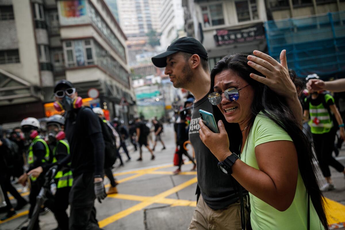 People watch emotionally as protesters retreat in Hong Kong ahead of advancing police.