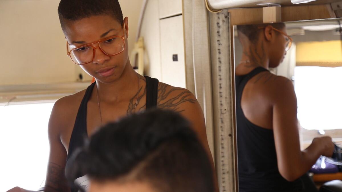 Founder and lead hairstylist of Project Q, Madin Lopez, cuts hair in their trailer outside the Los Angeles LGBT Center.