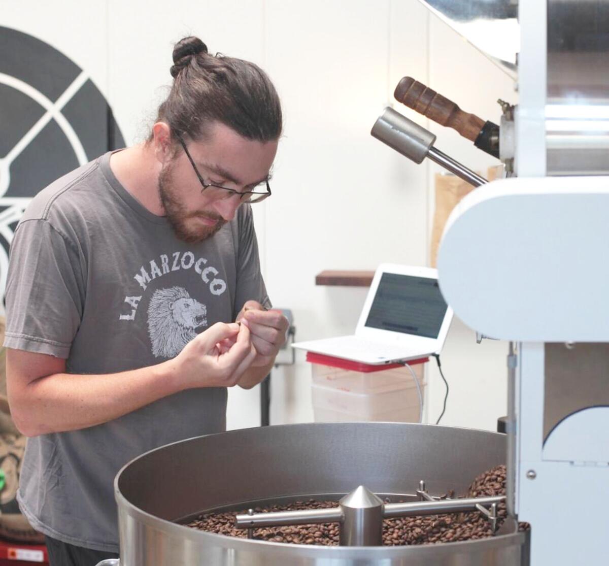 Coffee Cycle owner Chris O’Brien examining roasted beans.