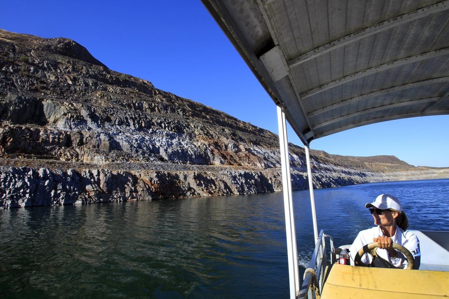 Sheri Shaffer, a manager with the Metropolitan Water District of Southern California, drives a boat past dry, rocky banks that reveal how far the water in Diamond Valley Lake in Hemet has receded. A group of scientists ran the state through a virtual mega-drought to see how it would fare.