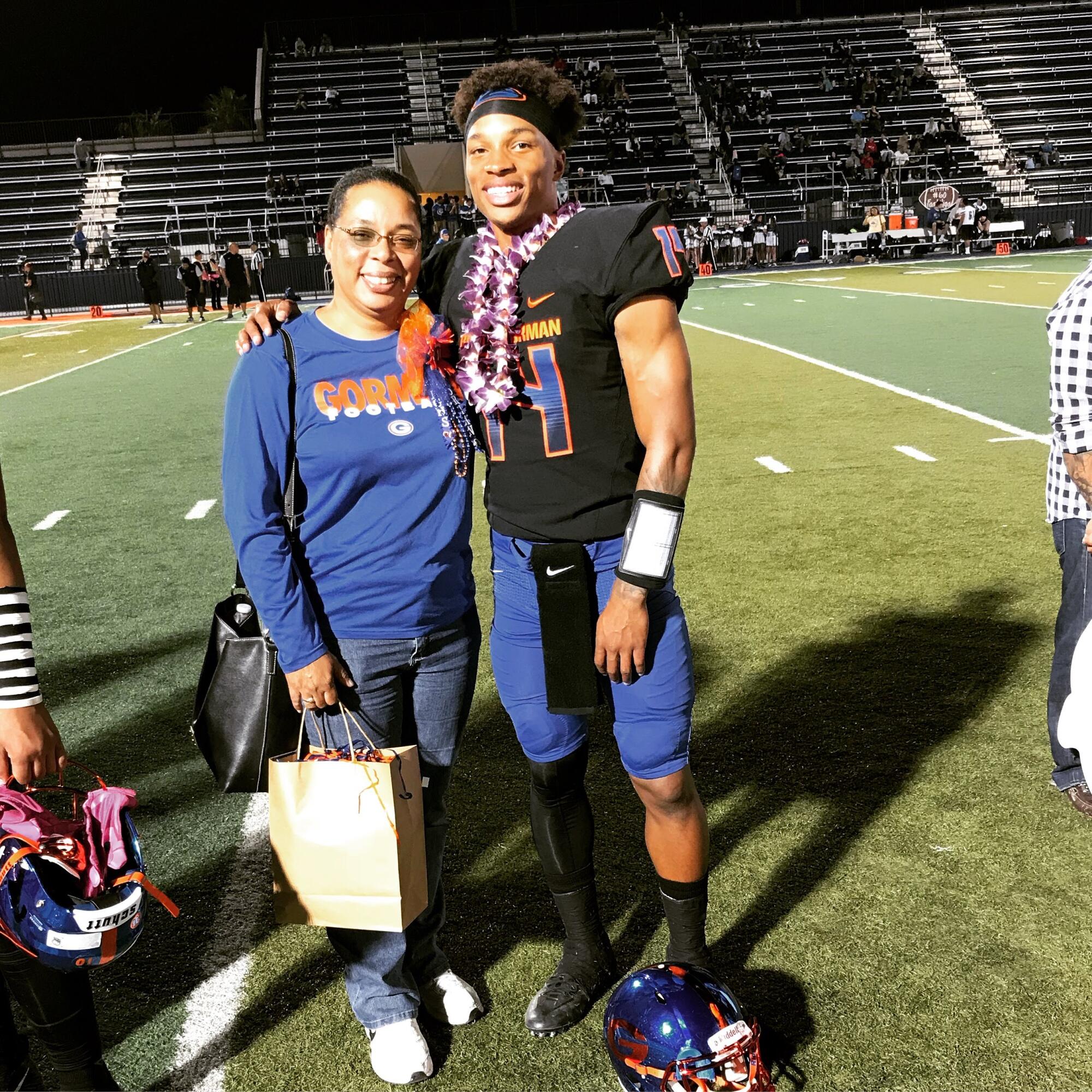 Quarterback Dorian Thompson Robinson embraces his mom, Melva Thompson-Robinson, on senior night at Bishop Gorman High