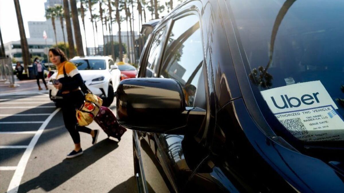 A passenger exits an Uber car at Union Station in Los Angeles.