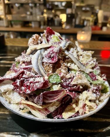 A Caesar salad with large anchovies and a mix of little gems and chicory
