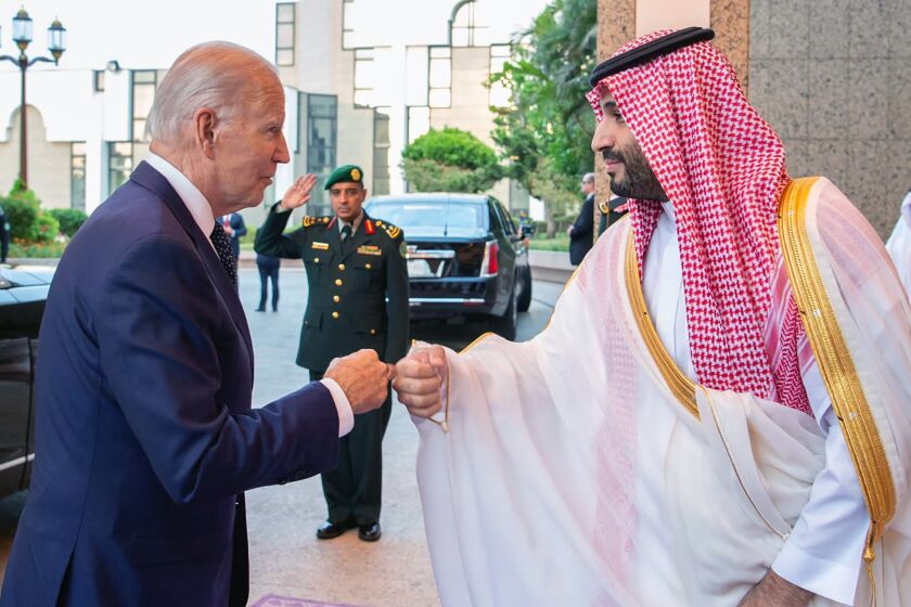 Crown Prince Mohammed bin Salman, right, greets President Biden, with a fist bump