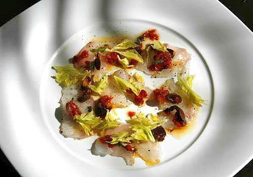 A crudo dish of sea bass with olives and tomatoes prepared by Michael Reardon, chef of Catch restaurant.