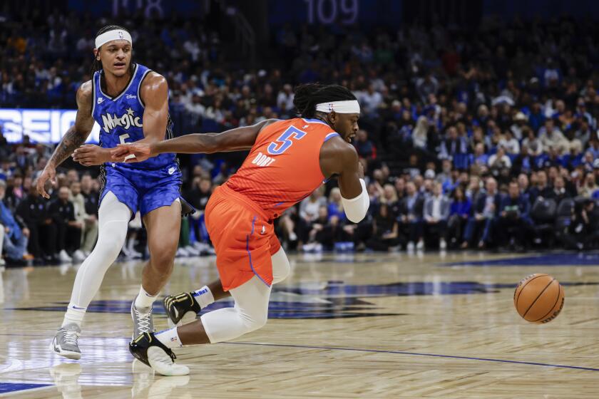 Luguentz Dort, del Thunder de Oklahoma City, despoja del balón a Paolo Bahchero, alero del Magic de Orlando, en el partido del martes 13 de febrero de 2024 (AP Foto/Kevin Kolczynski)