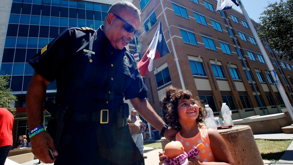 Sgt. Leroy Quigg greets a young well-wisher outside Dallas police headquarters.