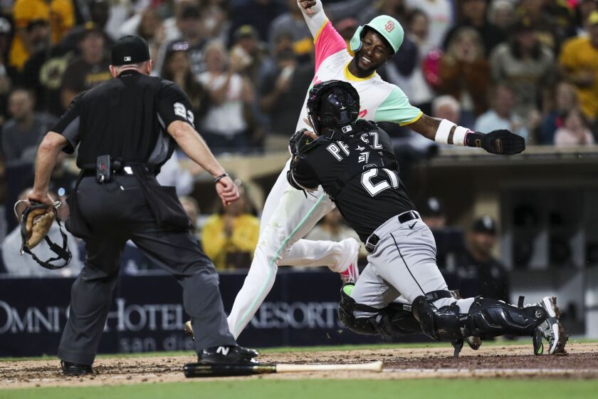 San Diego, CA - September 30: Padres left fielder Jurickson Profar (10) smiles as White Sox catcher Carlos Perez (21) tags him out at home plate during the fifth inning at Petco Park on Friday, Sept. 30, 2022 in San Diego, CA. (Meg McLaughlin / The San Diego Union-Tribune)