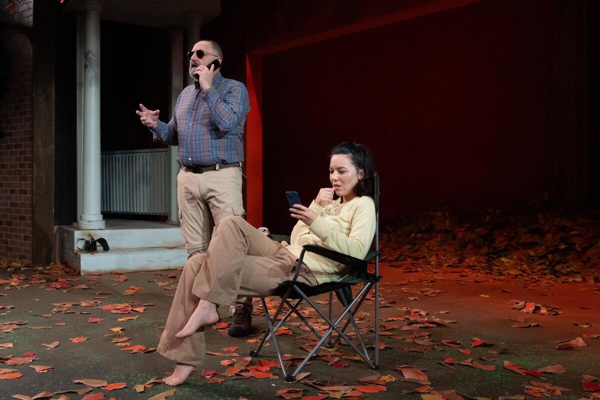 A man speaks on the phone while a woman sits in a chair in "Birds of North America" at the Odyssey Theatre.