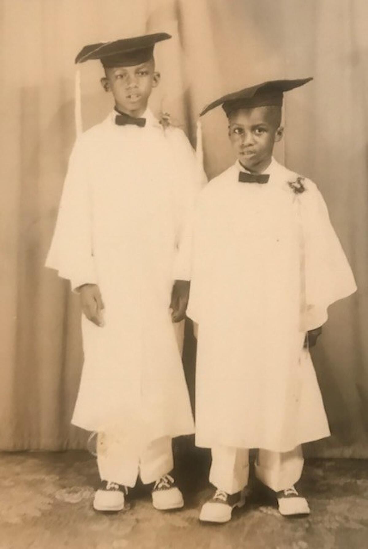 Big Willie and his younger brother Don Ray Robinson wear caps and gowns for a school graduation photo.
