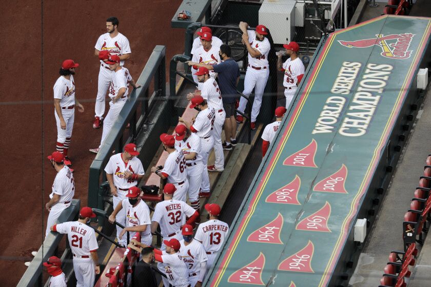 Members of the St. Louis Cardinals wait to be introduced before the start of a baseball game against the Pittsburgh Pirates Friday, July 24, 2020, in St. Louis. (AP Photo/Jeff Roberson)