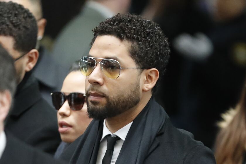 Former "Empire" actor Jussie Smollett, center, arrives for an initial court appearance Monday, Feb. 24, 2020, at the Leighton Criminal Courthouse in Chicago, on a new set of charges alleging that he lied to police about being targeted in a racist and homophobic attack in downtown Chicago early last year. (AP Photo/Charles Rex Arbogast)
