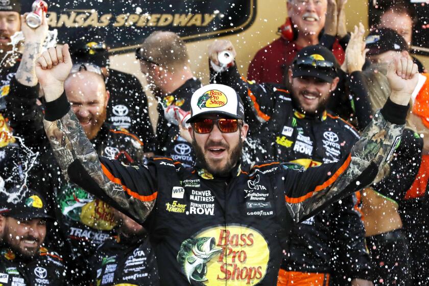 Martin Truex Jr. celebrates winning the NASCAR Cup Series auto race at Kansas Speedway in Kansas City, Kan., Sunday, Oct. 22, 2017. (AP Photo/Colin E. Braley)