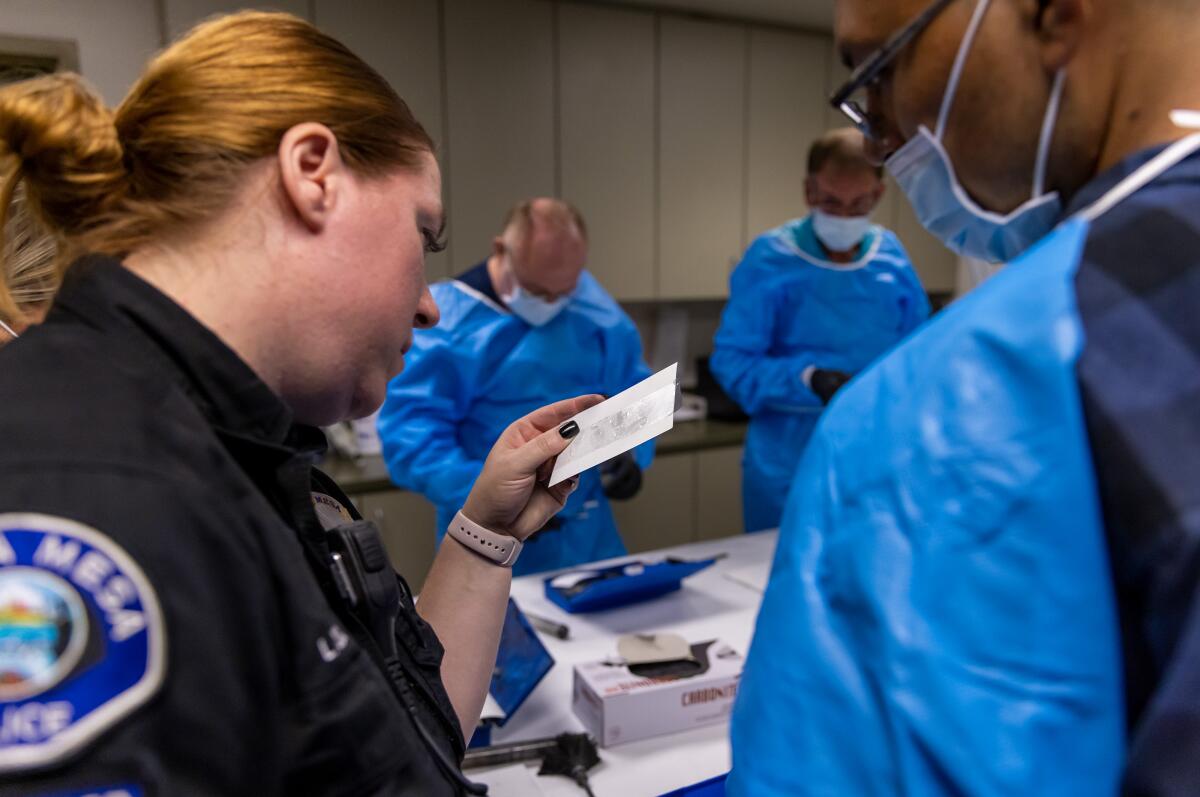 CSI Supervisor Lindsay Olsen checks participants' fingerprints at the Costa Mesa Citizen's Police Academy.