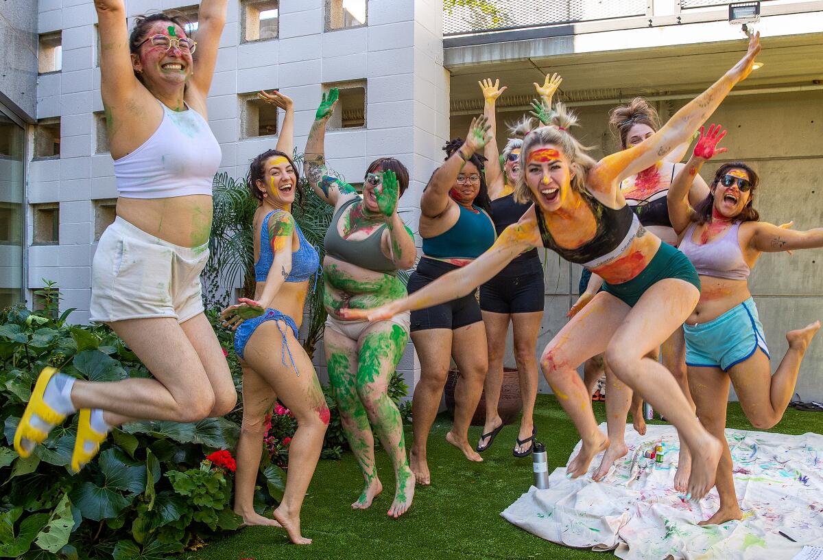 Women pose together after a body painting workshop, one of the activities during a Malibu wellness retreat.