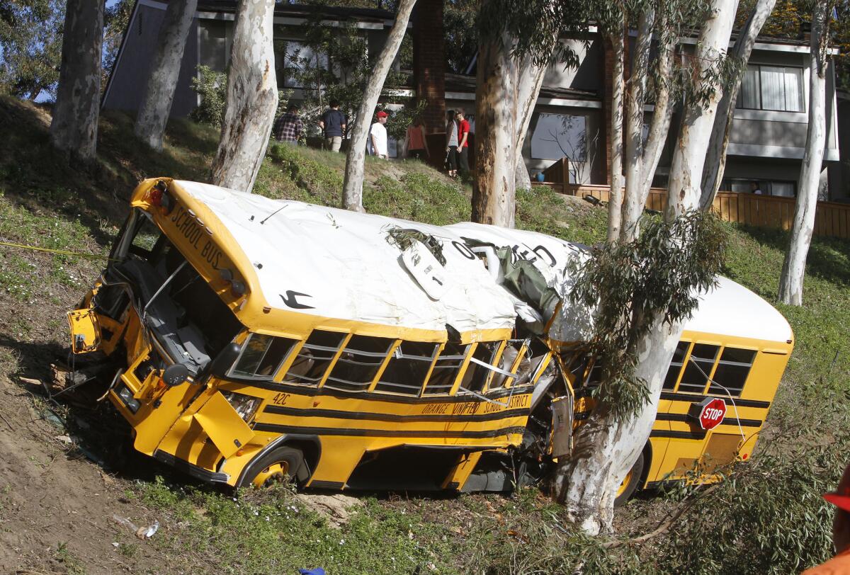 Highway patrol and Anaheim police investigate at the scene of a bus crashed near a golf course in Anaheim Hills.