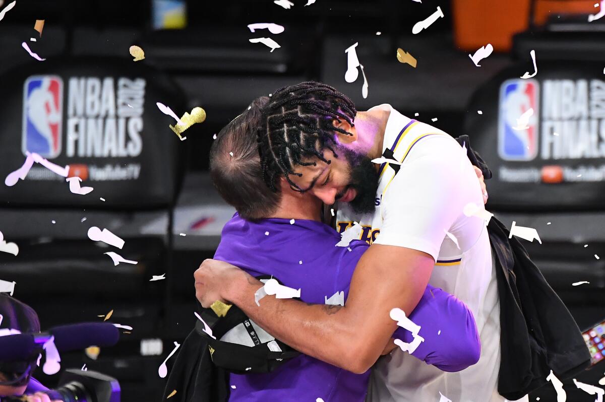 Lakers star Anthony Davis embraces coach Frank Vogel after winning the NBA title on Sunday.