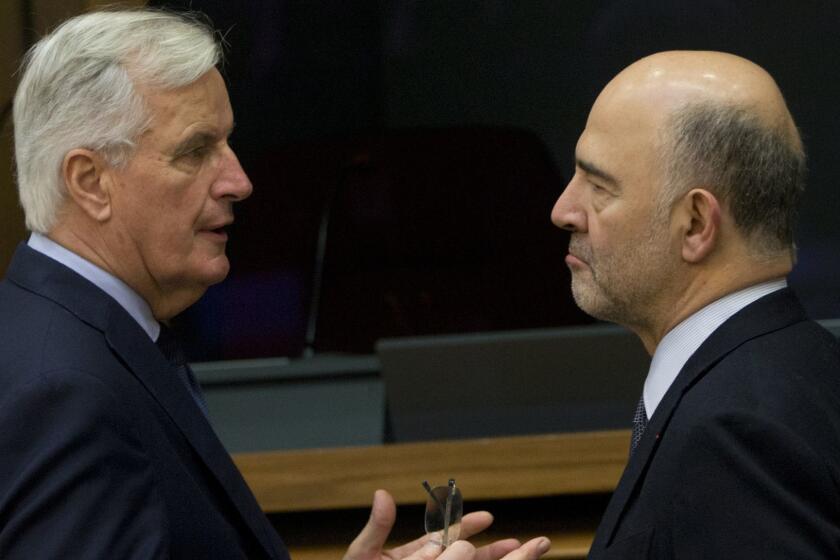 European Union chief Brexit negotiator Michel Barnier, left, speaks with European Commissioner for Economic and Financial Affairs Pierre Moscovici during a meeting of the College of Commissioners at EU headquarters in Brussels, Wednesday, Dec. 19, 2018. The European Commission held its weekly meeting on Wednesday as the European Union's executive arm prepares to release a series of documents laying out preparations for a no-deal Brexit scenario. (AP Photo/Virginia Mayo)