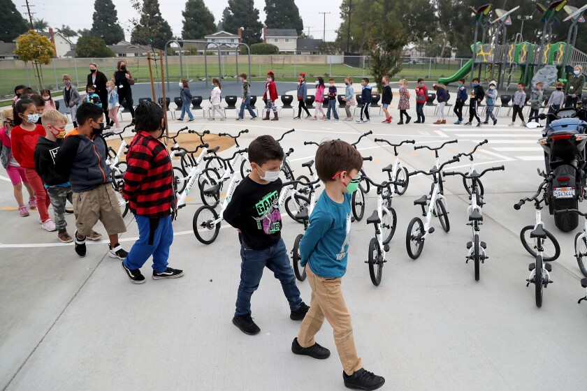 College View Elementary kindergarten students walk in a line as they view Strider bikes donated by IMS Outdoors on Thursday.